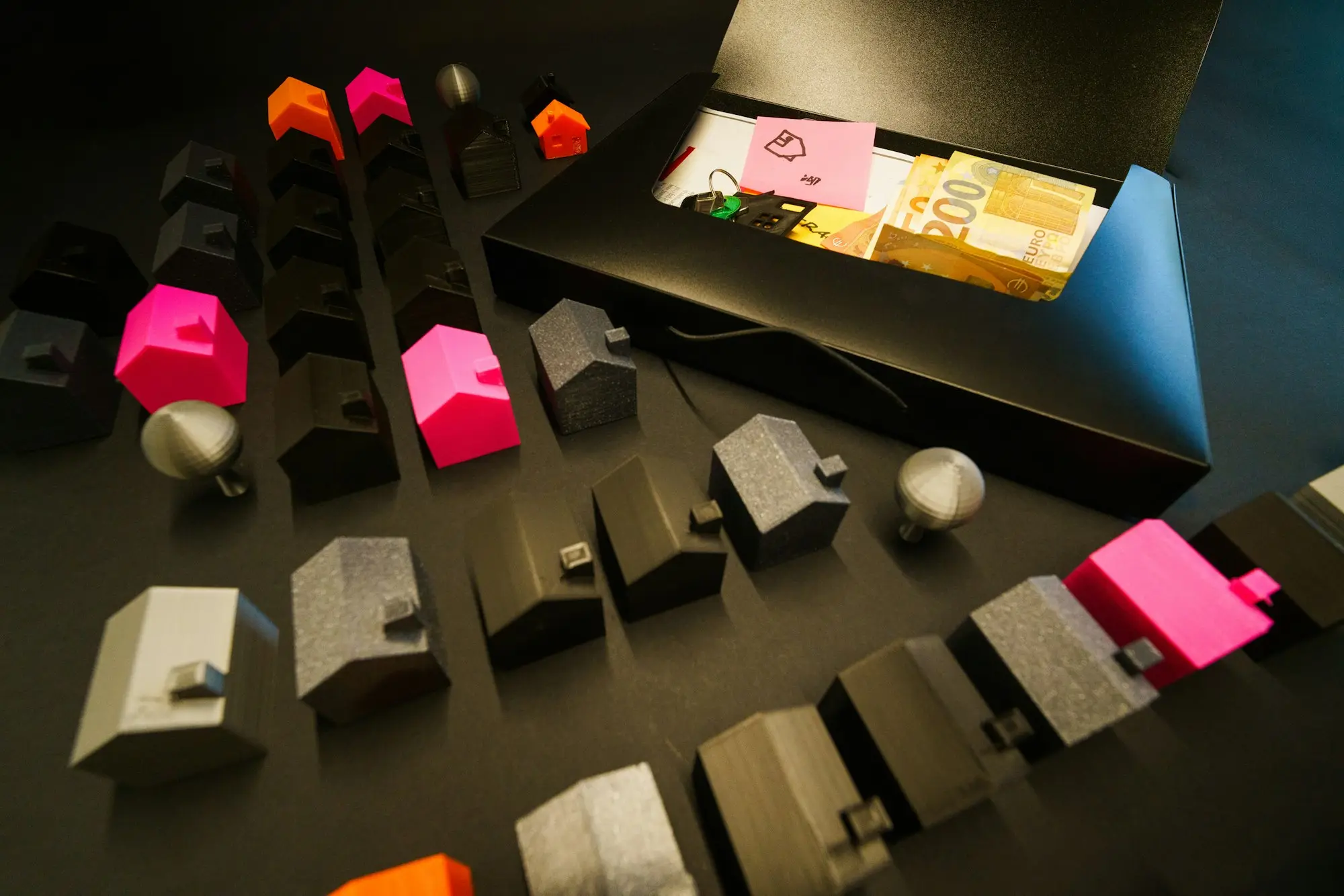 Miniature model houses arranged in an open box with banknotes, illustrating property equity